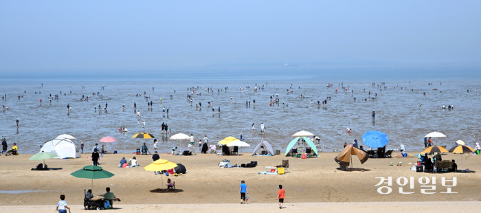 수도권 지역 한낮 기온이 28도까지 오르며 초여름 날씨를 보인 28일 오후 안산시 단원구 방아머리 해변을 찾은 시민들이 갯벌체험을 하며 더위를 식히고 있다./2024.4.28 임열수기자 pplys@kyeongin.com